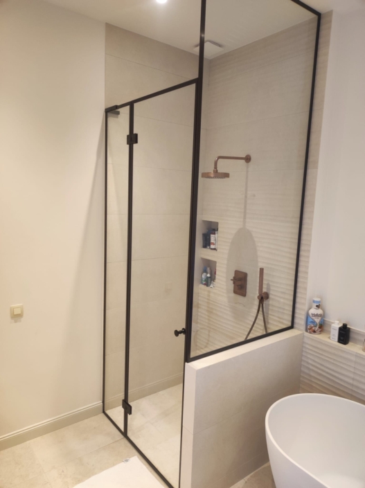 Installation de parois de douche en verre sur-mesure style atelier avec profils noirs dans un hôtel particulier à Nice.