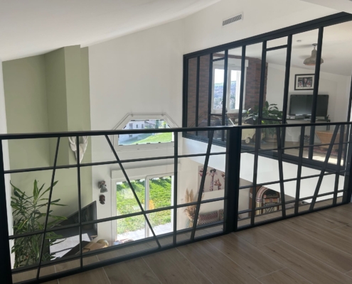 Vue d'ensemble d'une verrière et garde-corps en verre sur-mesure en mezzanine.