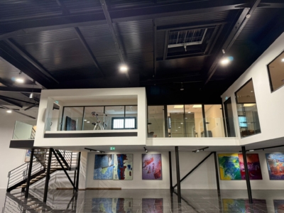 Installation de deux escaliers en acier et bois avec garde-corps en verre transparent dans un showroom automobile à Aix-en-Provence.