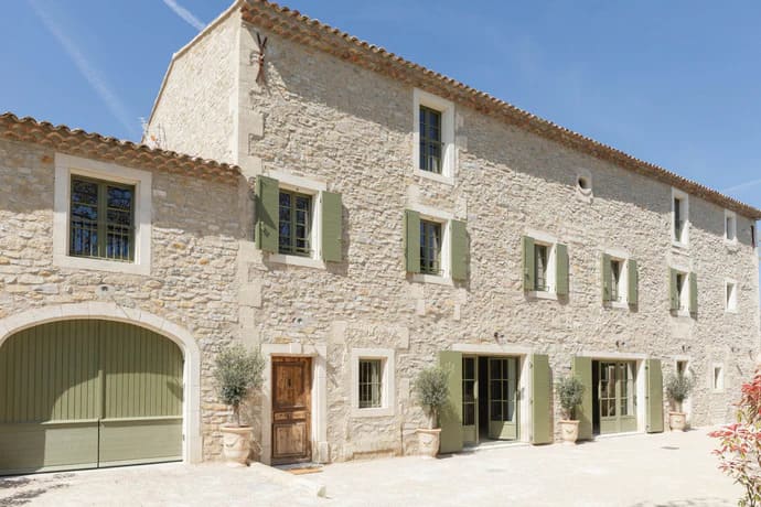 Aménagement d'un moulin à huile à Eyguières avec des menuiseries vitrées en acier et un escalier en colimaçon par SFML.